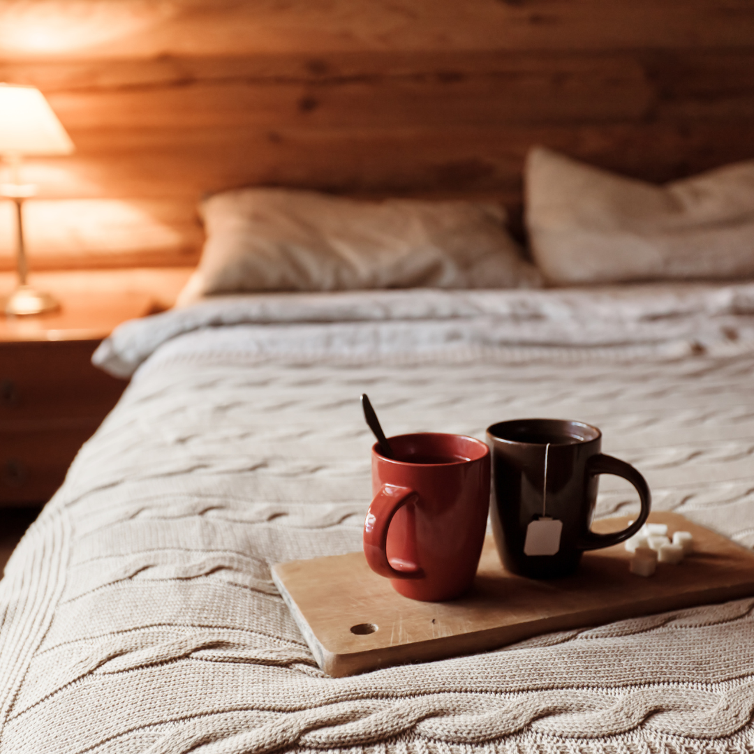 two mugs on a bed in a cabin