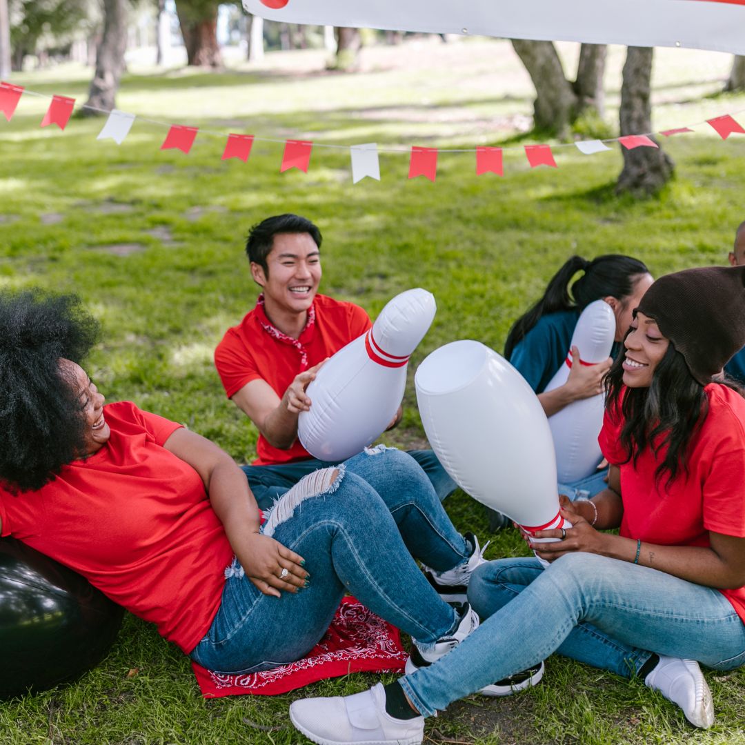 Group of people smile and laugh with inflatable bowling pins
