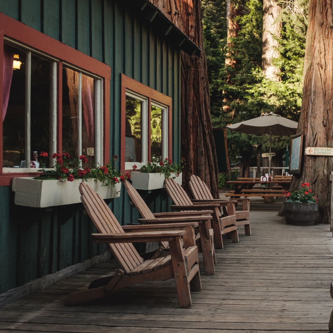 chairs on deck of mountain resort with trees in background