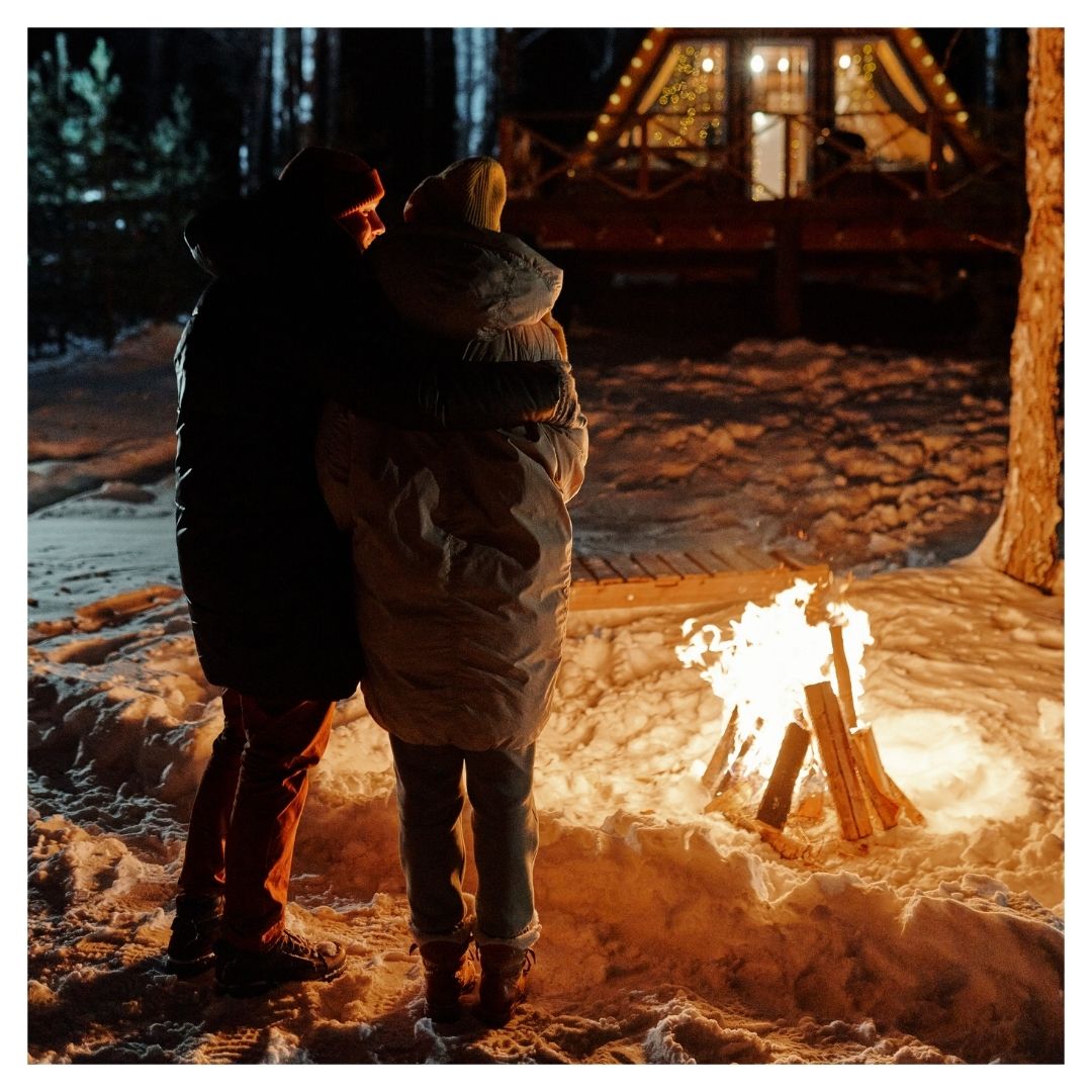 couple standing by a fire